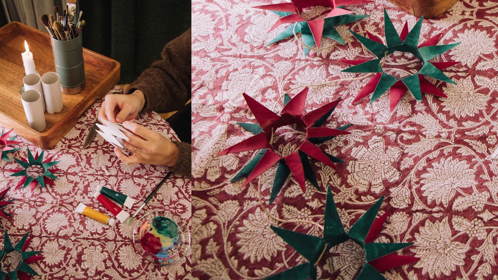 En kvinna gör en stjärndekoration av papper.